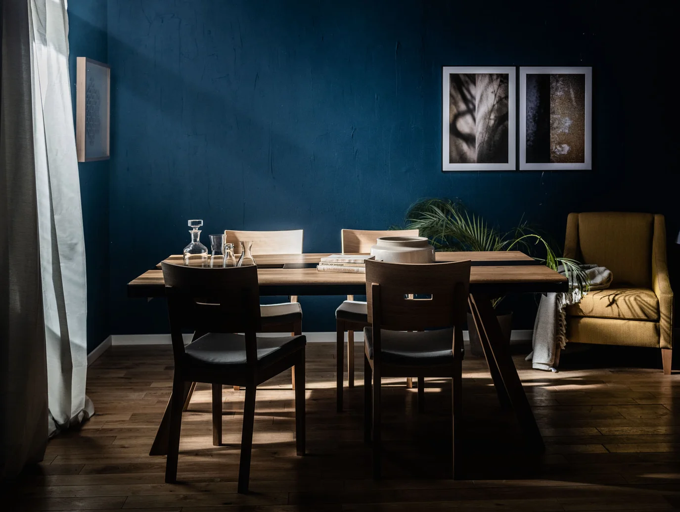 Elegancka jadalnia z ciemnoniebieską ścianą